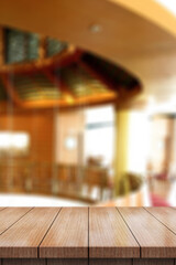 Fototapeta premium Empty wooden table top with lights bokeh on blur restaurant background.