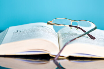 a stack of books and glasses are on the table