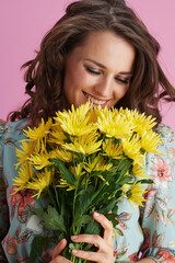 smiling young female in floral dress on pink