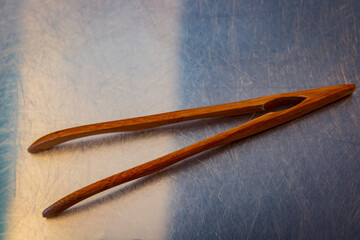 Fashionable wooden tweezers on a metal tabletop for grooming purposes