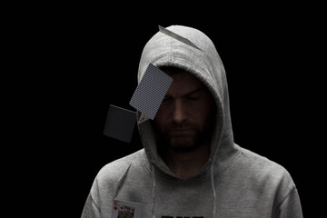 Man in hoody with flying playing cards