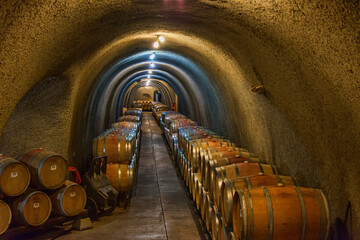 Wine barrels stacked in an old cellar at a winery in Sonoma, USA