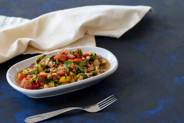 Healthy vegetarian food, traditional flavor Gavurdagi Salad with walnut. coban or choban salad. Mezze served alongside the main course. Appetizer