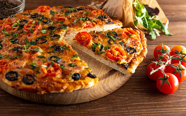 Pizza with cheese, olives, tomatoes and herbs.