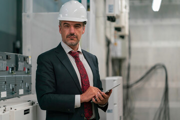 Portrait shot of senior engineer or management inspecting work in the electrical control room