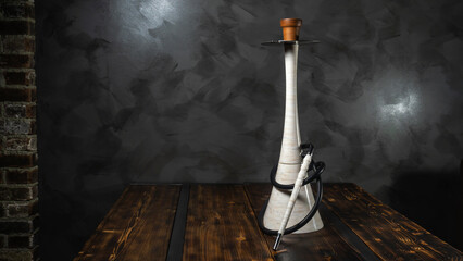 Modern white artificial stone marble hookah on the light grey wall background. Space for text. Lounge and relax concept.