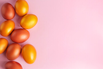 Shining golden eggs on a pink background. Happy Easter.