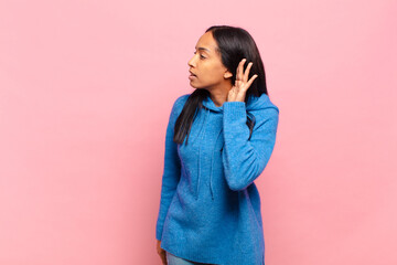 young black woman looking serious and curious, listening, trying to hear a secret conversation or...
