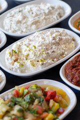 Traditional Turkish and Greek food appetizer table. Grilled eggplant salad (saksuka), Anamur salad, Baba Ghanoush (Mutabbal), pasha appetizer, spicy paste or harissa, purslane salad. Selective focus