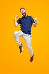 Excited man celebrating success and jumping high