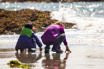 Children beach exploring at low tide while on vacation at Pacific Rim National Park near Tofino British Columbia.