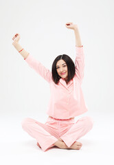 Woman morning stretching in pink pajamas smiling isolated on white background.