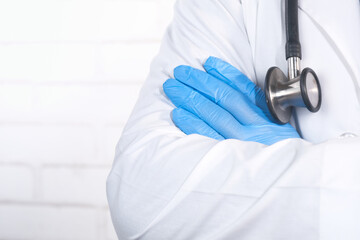 close up of doctor with arms crossed and stethoscope on neck ,