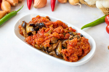 Grilled eggplant salad appetizer with tomato sauce (with eggplant sauce or saksuka). Traditional Middle Eastern meze beside the main course. Layout on white wood