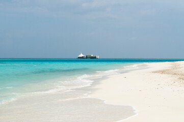 Fototapeta na wymiar Paisaje deploy de arena blanca y aguas turquesas en el atolón de Islas Maldivas, Océano índico