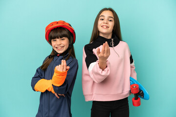 Little sisters practicing cycling and skater isolated on blue background inviting to come with hand. Happy that you came