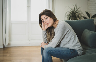 Obraz premium Young sad woman suffering from depression feeling desperate and lonely at home