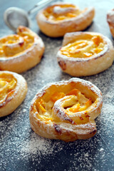 Sweet puff pastry roll for breakfast or snack on dark background. Healthy breakfast or snack for children. Top view with copy space.