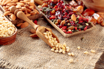 Dried fruits, various nuts and seeds on a wooden table.