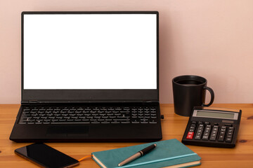 Fototapeta premium Office desk with laptop, smartphone, cup of coffee, pen, pen and laptop. Office supplies and appliances on the desk