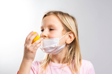 Anosmia or smell blindness, loss of the ability to smell, one of the possible symptoms of covid-19, infectious disease caused by corona virus. Girl Trying to Sense Smell of a Lemon, side view.