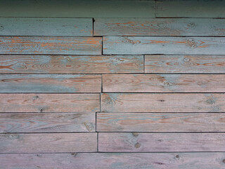 Texture of old wooden planks arranged horizontally with faded blue paint. Without people. Old village house made of wooden planks, with peeling paint. As a background or desktop wallpaper. 