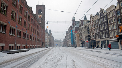Snowy city Amsterdam at the Damrak in winter in the Netherlands
