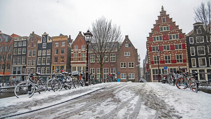 Fototapeta premium Snowy city Amsterdam in winter in the Netherlands