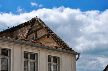 Teilansicht eines Gebäudes ,dieses beginnt zu zerfallen, das Dach fehlt bereits zum Großteil. Der Blick geht gegen einen traumhaften Sommerhimmel