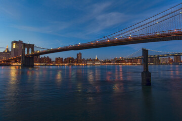 Fototapeta na wymiar scene of New york Cityscape with Brooklyn Bridge over the east river at the twilight time, USA downtown skyline, Architecture and transportation concept