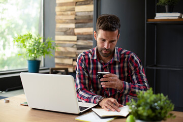 Young businessman drinking coffee in his office. Businessman on coffee break.