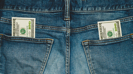 100 dollar bills in the back pockets of jeans