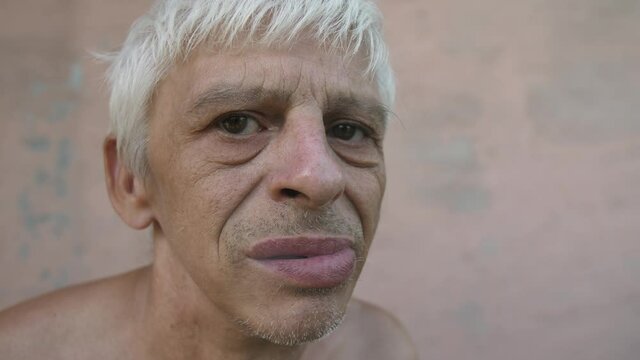 Distrustful man looks at camera and smoking