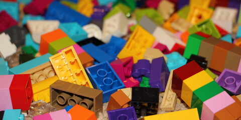 Fototapeta na wymiar A lot colorful bricks from the children's model kit, a texture for the background
