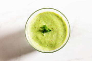 Healthy green kale smoothie with greek yogurt in a glass isolated on white table background, top view. Kale is considered a superfood because it's a great source of vitamins and minerals.