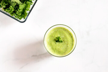 Healthy green kale smoothie with greek yogurt in a glass isolated on white table background, top view. Kale is considered a superfood because it's a great source of vitamins and minerals.