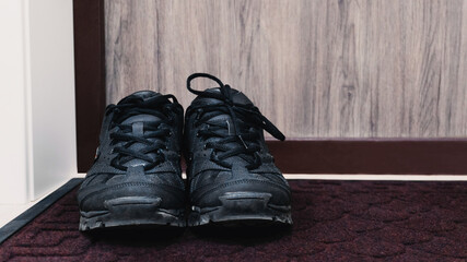 Shoes black sneakers on the doorstep