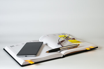 Diary, glasses, smartphone and pen on a white background. Business concept
