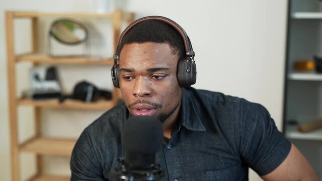 A black man charismatically records his conversation on a microphone