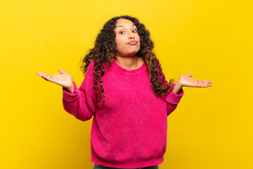 young hispanic woman feeling puzzled and confused, unsure about the correct answer or decision,...