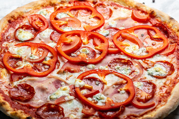 A piece of Pizza with pepper, tomatoes, ham on a light background. Italian cuisine. Food recipe background. Close up