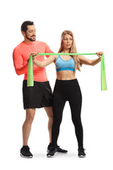 Male fitness trainer showing an exercise to a woman with an elastic band