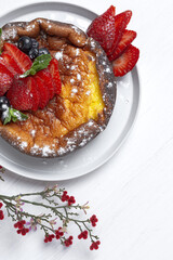 Homemade cheesecake with blueberries, currants, strawberries and mint leaves from above. Flat lay