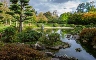 Fototapeta na wymiar Amazing view with pond and stones in japanese garden in Nordpark in Dussreldorf