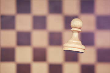 White chess piece pawn and vintage shabby chessboard. Competition and game study, concept