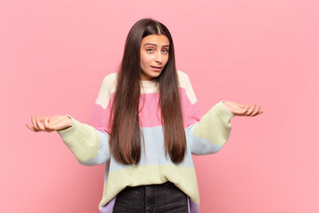 young pretty woman feeling clueless and confused, not sure which choice or option to pick, wondering
