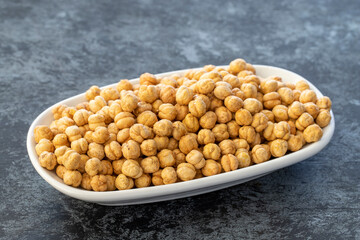 Roasted chickpeas on plate on dark background