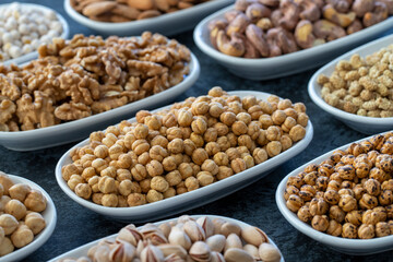 Roasted chickpeas in selective focus. Nuts on plate on a dark background. Walnut, Chickpeas, White Chickpeas, Dry mulberry, almond, cashew, pistachio. Types of nuts on the plate.