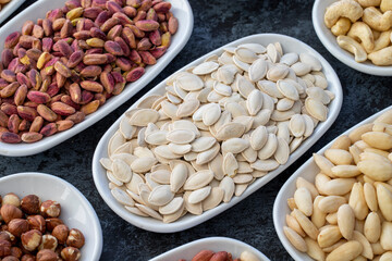 Pumpkin Seeds in selective focus. Types of nuts found in bulk on a dark background. Top view nuts