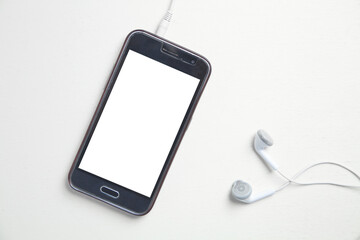 Smartphone with a earphones on white desk.